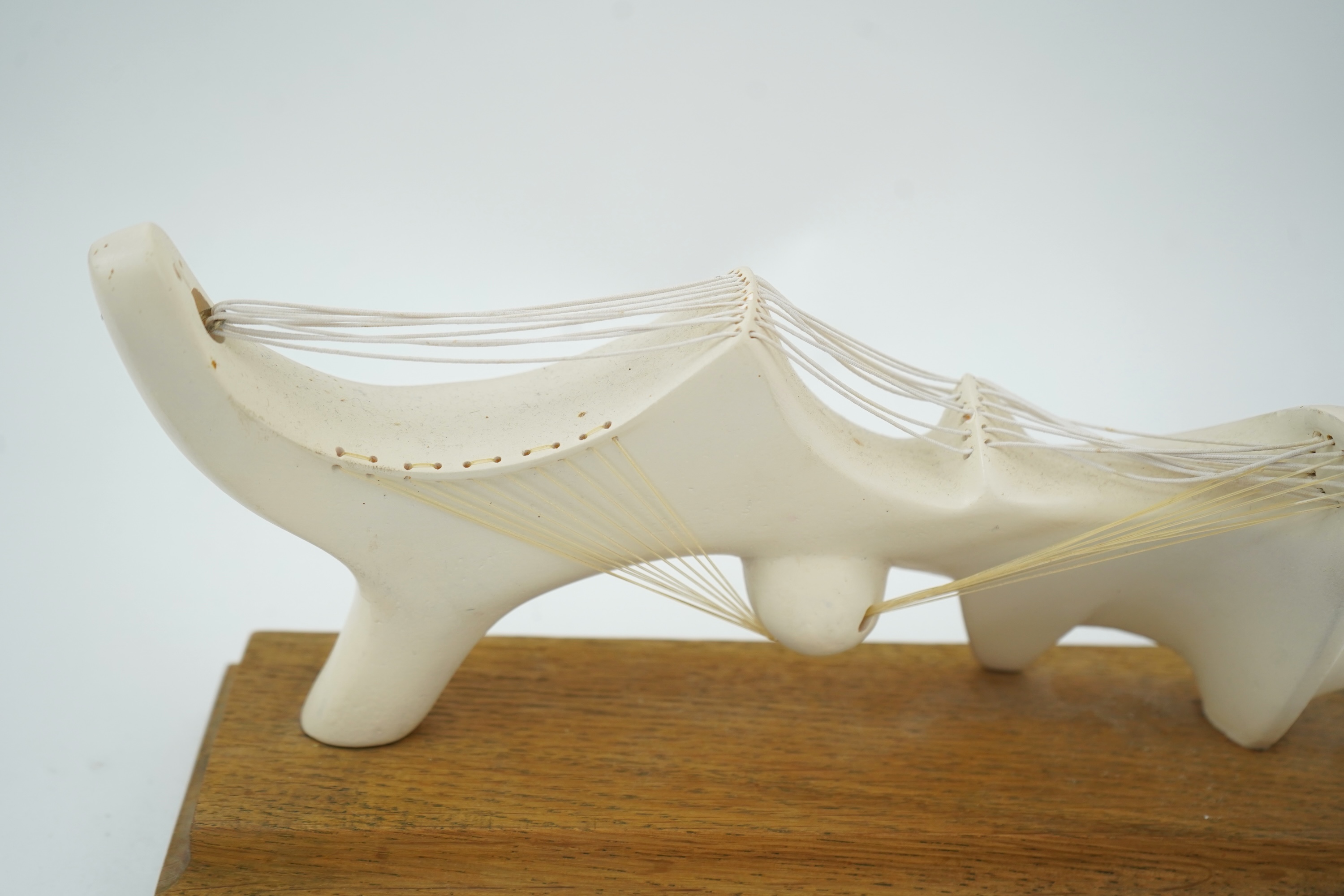 Follower of Henry Moore (1898-1986) A modernist stringed plaster sculpture raised on an oak rectangular plinth base, 25cm wide